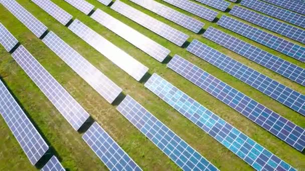 Survolez un champ de panneaux solaires lors d'une journée ensoleillée d'été. Innovation écologique. — Video