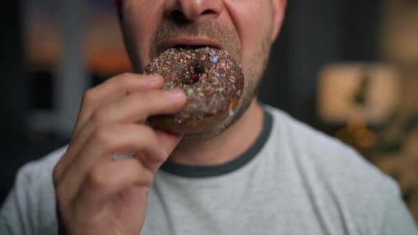 Hombre comiendo apresuradamente donut de chocolate dulce. Primer plano — Vídeo de stock