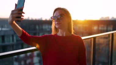 Balkonda selfie çeken bir kadın.