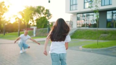 Kızı babasına koşuyor ve ona sarılıyor. Baba çocuğu kollarına alır. Yavaş çekim