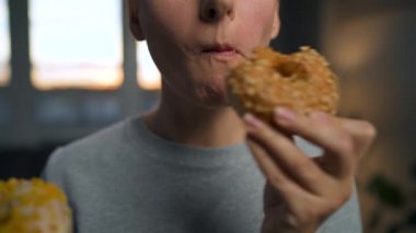 Güzel bağımlılık konsepti. Kadın aynı anda iki çörek yiyor..