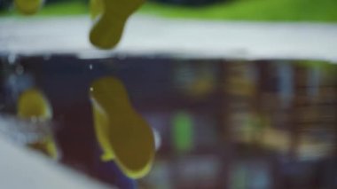 Bayan sporcu kadın dışarıda koşuyor, su birikintisine giriyor. Yağmurda koşan tek koşucu, su sıçratıyor. Yavaş çekim