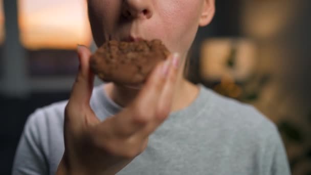 女性はチョコレートチップクッキーを食べる — ストック動画