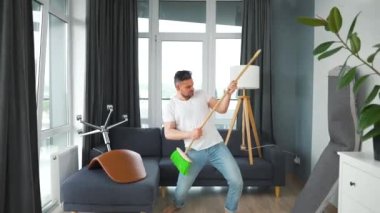 Adam temizlik yapıyor ve kendini rock yıldızı olarak hayal ediyor. Süpürgeyi gitar gibi çalıyor..