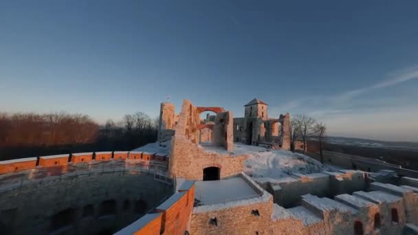 Kışın gün batımında tepedeki güzel tarihi şatonun havadan görünüşü harabeye döner. Tenczyn Kalesi, Polonya. FPV insansız hava aracı ile çekildi. — Stok video