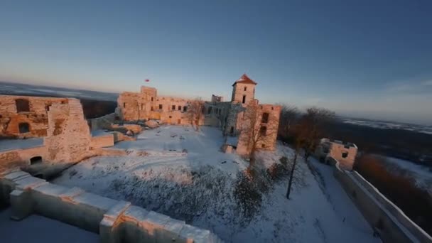 Veduta aerea di bellissime rovine storiche del castello sulla collina in inverno al tramonto. Castello di Tenczyn, Polonia. Girato su drone FPV. — Video Stock