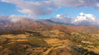 Yunanistan 'daki Girit adasının havadan görünüşü. Dağ manzarası, zeytin ağaçları ve bulutlu gökyüzü.
