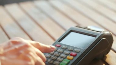 Akıllı telefondan yapılan temassız ödeme. Kablosuz ödeme konsepti. Yakın plan, kadın banka terminalindeki siparişi ödemek için akıllı telefon nakitsiz cüzdan teknolojisi kullanıyor..