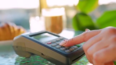 Akıllı telefondan yapılan temassız ödeme. Kablosuz ödeme konsepti. Yakın plan, kadın bir kafedeki banka terminalinin siparişini ödemek için akıllı telefon nakitsiz cüzdan teknolojisi kullanıyor..