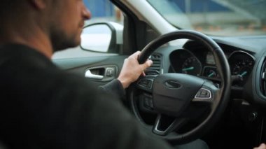 Otomatik otopark için otopark pilotu kullanan bir adam yenilikçi bir otomobil kullanıyor. Sürücülerin omuzlarının arkasından arka görüş
