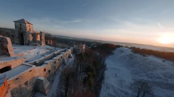 Kışın gün batımında tepedeki güzel tarihi şatonun havadan görünüşü harabeye döner. Tenczyn Kalesi, Polonya. FPV insansız hava aracı ile çekildi. — Stok video