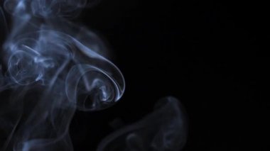Soyut duman siyah arka planda güzel girdaplarda yükselir. Yavaş çekim