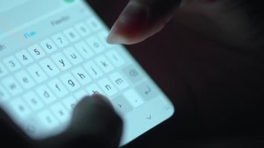 Akıllı telefondan yazı yazan bir kadın eli. Yakın plan. Akşamları akıllı telefonları kullanarak.