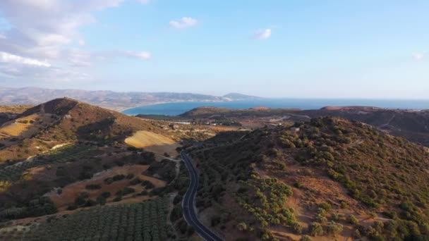 クレタ島、ギリシャの空中ビュー。日没の光の中で山の風景、道路、ブドウ畑や海. — ストック動画