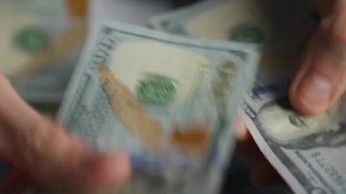 Amerikan dolarlarını sayan ya da nakit ödeyen eller. Yatırım, başarı, finansal beklentiler veya kariyer ilerlemesi kavramı