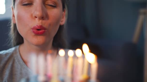 Feliz mulher animada fazendo desejo estimado e soprando velas no bolo de férias, celebrando aniversário em casa, câmera lenta — Vídeo de Stock