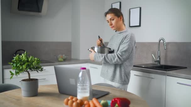 Donna alla ricerca di ricetta online durante la cottura — Video Stock