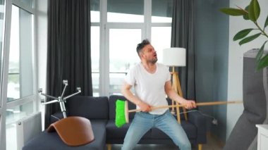 Adam temizlik yapıyor ve kendini rock yıldızı olarak hayal ediyor. Süpürgeyi gitar gibi çalıyor. Yavaş çekim