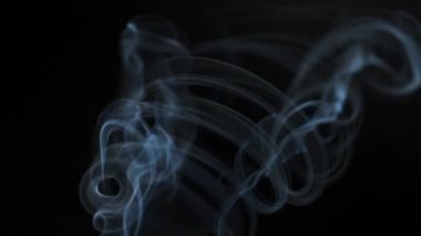 Soyut duman, siyah arka planda güzel girdaplarda yükselir.
