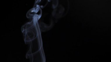 Soyut duman siyah arka planda güzel girdaplarda yükselir. Yavaş çekim