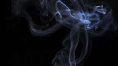 Soyut duman siyah arka planda güzel girdaplarda yükselir. Yavaş çekim