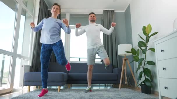 Kaukasisches Paar macht Cardio-Training zu Hause in gemütlichem, hellen Raum. — Stockvideo