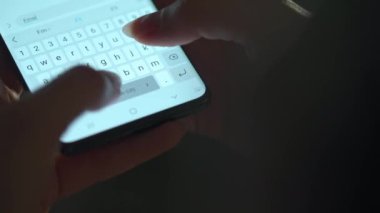 Akıllı telefondan yazı yazan bir kadın eli. Yakın plan. Akşamları akıllı telefonları kullanarak.