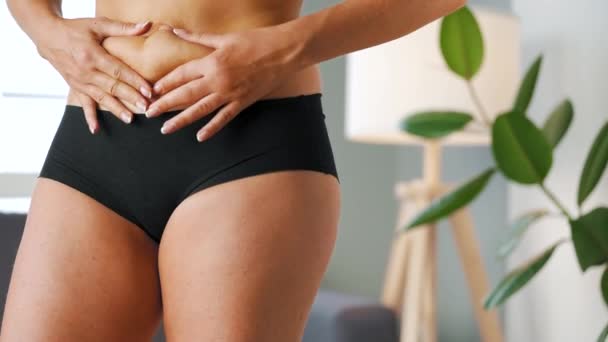 Vrouw comprimeert de huid op haar maag controleren op cellulitis en overtollig onderhuids vet — Stockvideo