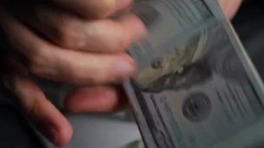 Amerikan dolarlarını sayan ya da nakit ödeyen eller. Yatırım, başarı, finansal beklentiler veya kariyer ilerlemesi kavramı