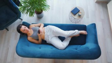 Kablosuz kulaklık takan, müzik dinleyen, mobil uygulama kullanan ya da sosyal ağlarda akıllı telefondan iletişim kuran bir kadın.