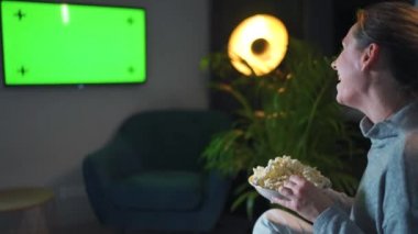Akşamları oturma odasındaki kanepede oturan ve yeşil ekran maketini izleyen bir kadının arka görüntüsü gördüklerine seviniyor..