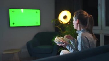 Akşamları oturma odasındaki bir kanepede oturan ve yeşil ekran maketini izleyen bir kadın gördüklerinden dolayı duygusal olarak endişeli. Kadın patlamış mısırı izlemeyi ve yemeyi çok seviyor..