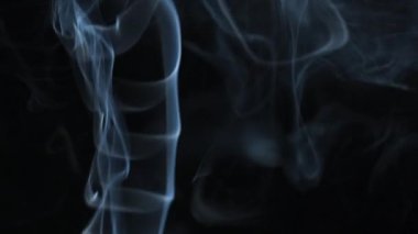 Soyut duman siyah arka planda güzel girdaplarda yükselir. Yavaş çekim