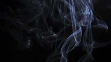 Soyut duman siyah arka planda güzel girdaplarda yükselir. Yavaş çekim