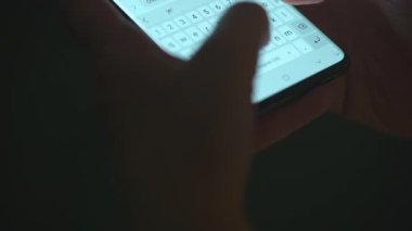 Akıllı telefondan yazı yazan bir kadın eli. Yakın plan. Akşamları akıllı telefonları kullanarak.