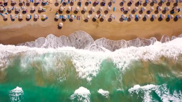 Flygfoto över havet, sandstrand, parasoller och solstolar, oigenkännliga människor. Vacker semester och turism destination på Kreta, Grekland. — Stockvideo