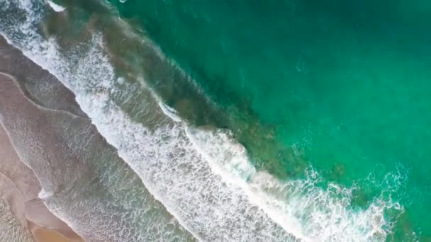 Вид с воздуха на побережье Средиземного моря, волны достигают пустынного песчаного пляжа. Отдых и туризм на Крите, Греция. — стоковое видео