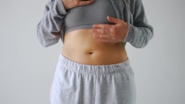 Kadın karnına baskı yapıp selülit ve aşırı deri altı yağ kontrolü yapıyor.