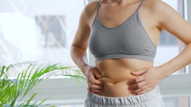 女人在腹部挤压皮肤，检查脂肪和多余的皮下脂肪 — 图库视频影像