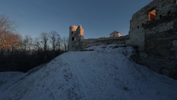 Vue aérienne de magnifiques ruines du château historique sur la colline en hiver au coucher du soleil. Château de Tenczyn, Pologne. Filmé sur drone FPV. — Video