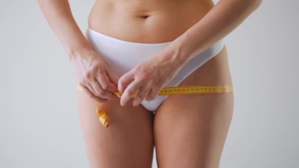 Mulher medindo suas coxas e cintura com uma fita métrica — Vídeo de Stock