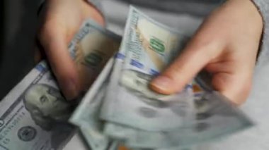 Amerikan dolarlarını sayan ya da nakit ödeyen eller. Yatırım, başarı, finansal beklentiler veya kariyer ilerlemesi kavramı