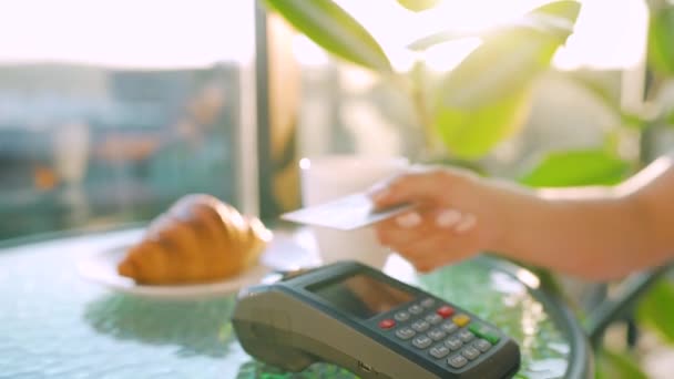 Оплата кредитной картой NFC. Женщина платит бесконтактной кредитной картой по технологии NFC для оплаты заказа на банковском терминале в кафе. Беспроводная денежная сделка. Беспроводная оплата — стоковое видео