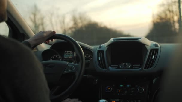 Een man rijdt een auto langs de weg. — Stockvideo