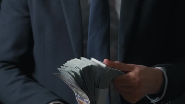 Un uomo vestito formalmente che conta banconote da un dollaro. Concetto di investimento, successo, prospettive finanziarie o avanzamento di carriera — Video Stock