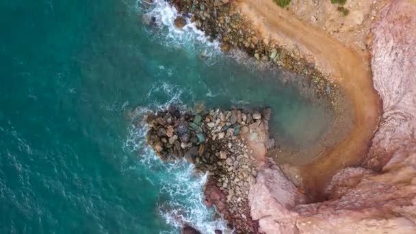 Blick von oben auf die Mittelmeerküste, Wellen erreichen die menschenleere Küste. Schönes Urlaubs- und Touristenziel in Griechenland. — Stockvideo
