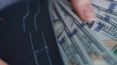 Kadın cüzdanını çıkarıp Amerikan dolarlarını sayıyor.