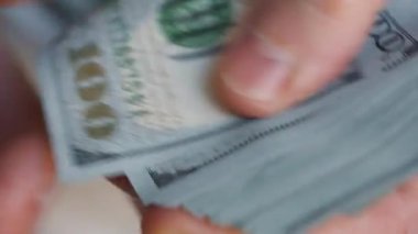 Amerikan dolarlarını sayan ya da nakit ödeyen eller. Yatırım, başarı, finansal beklentiler veya kariyer ilerlemesi kavramı