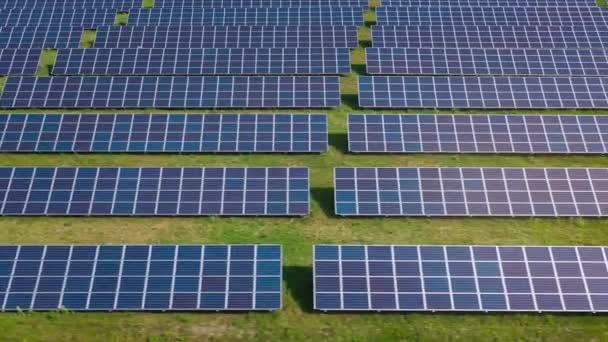 Survolez un champ de panneaux solaires lors d'une journée ensoleillée d'été. Innovation écologique. — Video