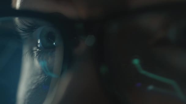 Extrémní detailní záběr monitoru se odráží v ženských brýlích. Žena pracující s grafy a analytikou. Práce v noci. — Stock video